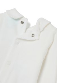 Indumento in pile bianco con colletto, chiusure a scatto e texture morbida. Presenta un cappuccio e bordi arrotondati per il comfort.