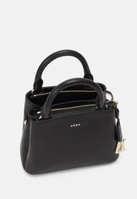 Borsa nera testurizzata con doppi manici superiori, cerniere dorate e logo DKNY sul fronte. Presenta un charm removibile. Design compatto.