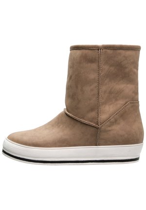 Lysebrun ruskindsstøvle til midtkalven med en hvid platåsål og sort stribe langs nederste kant, vist i profil.