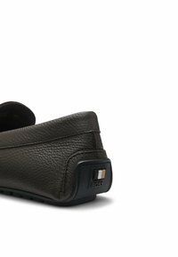 Vue arrière d'une chaussure mocassin en cuir texturé marron foncé avec un onglet de talon en caoutchouc noir arborant un détail logo BOSS métallique.