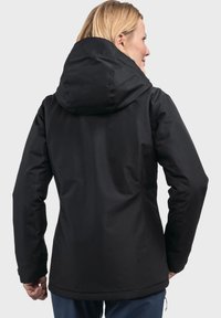 Zwarte waterdichte jas met capuchon, met een gladde textuur, aansluitende pasvorm, minimalistisch ontwerp en verstelbare manchetten.