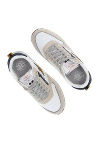 Sneaker beige e bianchi in tessuto a rete, con lacci grigi, dettaglio dorato sul tallone, logo sulla linguetta e suola in gomma testurizzata.