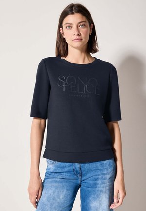 Körpernahe, kurzärmlige Bluse in Marineblau aus glattem Stoff, mit rundem Ausschnitt und einem Druckdesign in einer helleren Farbnuance.