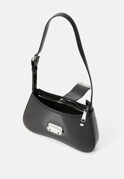 Bolso de hombro de piel negra con un diseño curvado, herrajes de plata, compartimento con cremallera y una textura suave. Incluye correa ajustable.