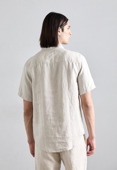 Linnen shirt in lichtbeige met korte mouwen, een ontspannen pasvorm en een afgeronde zoom. Heeft een button-down kraag en een subtiele textuur.