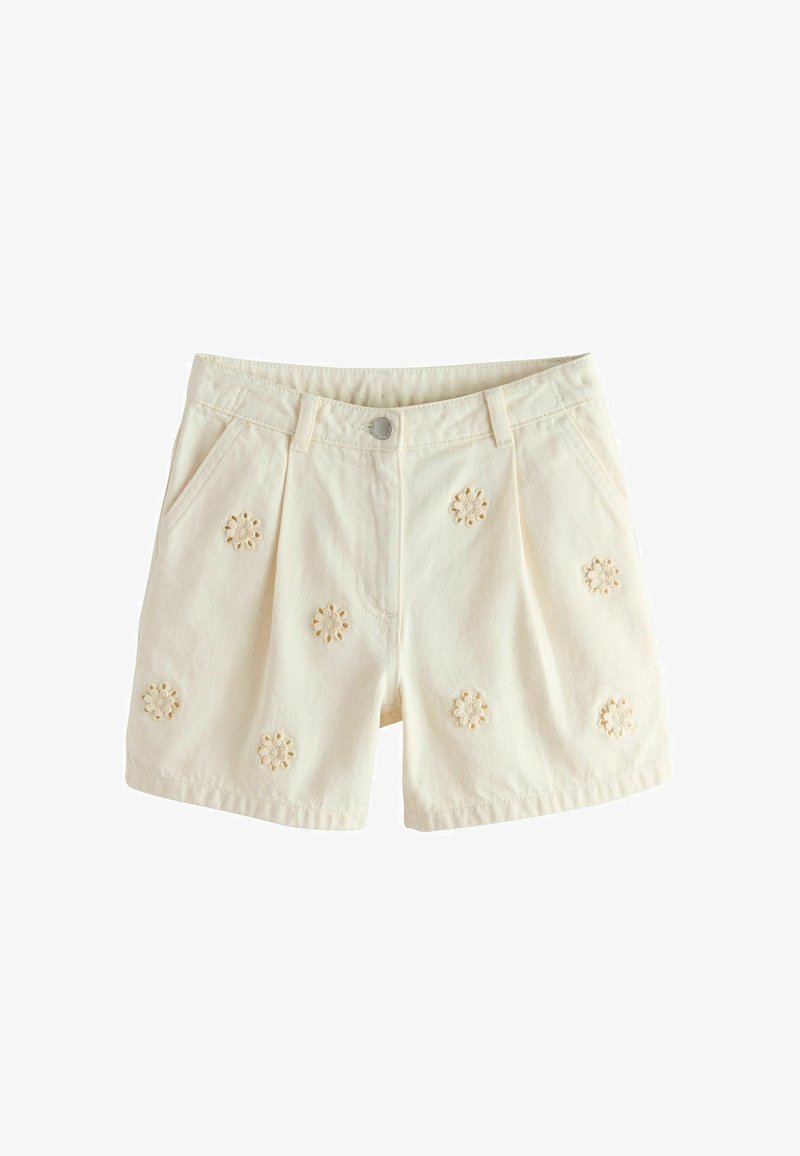 Shorts de couleur crème avec poches avant et motifs floraux découpés brodés dispersés sur le tissu.