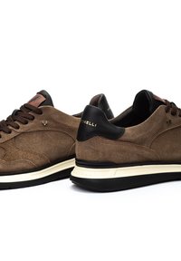 Zapatillas de ante marrón con un talón de cuero negro. Cordones en marrón oscuro, con un logo en la lengüeta y sutiles patrones en los laterales.
