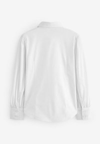 Camicia bianca a maniche lunghe con colletto, caratterizzata da maniche a sbuffo e polsini con bottoni. Tessuto morbido e vestibilità su misura con pince posteriori.
