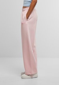 Rosa, højtaljede sweatpants med afslappet pasform, sidelommer, elastisk talje og et lille broderet logo i pink på låret.