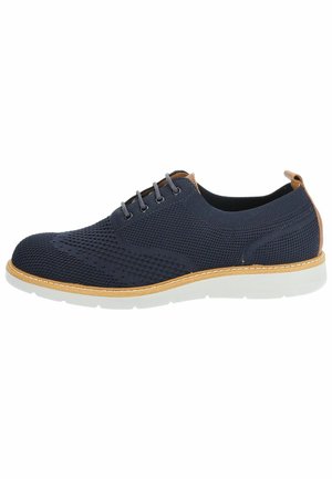 Scarpa in maglia blu navy con suola chiara, dettagli marroni, sei fori per i lacci e cuciture a contrasto. Design semplice, forma moderna.