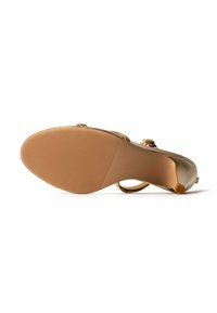 Sandalette mit strukturiertem Absatz und niedrigem Absatz, Seitenriemen mit Schnalle, von unten auf weißem Hintergrund dargestellt.