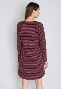 Abito a maniche lunghe con righe orizzontali bordeaux e bianche, realizzato in tessuto morbido con scollatura rotonda e orlo leggermente curvato.