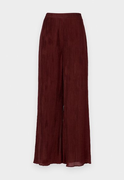 Bredde ben, burgunderfarget bukser laget av strukturert stoff med vertikale folder. Har høy midje og kanten faller til ankelen.