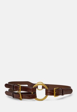 Double ceinture en cuir marron avec anneau métallique circulaire doré et boucles dorées sur fond blanc.