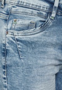 Helle blaue Denim-Jeans mit einem klassischen Fünf-Taschen-Design, sichtbaren Nähten und einer leicht abgenutzten Textur des Stoffes.
