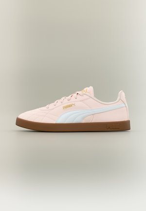 Lys rosa Puma-sneaker med hvit stripe, gullfarget logo og brun såle vist i sideprofil på nøytral bakgrunn.