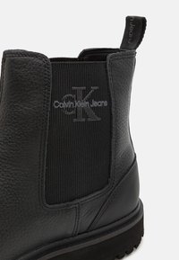Zwarte leren Chelsea-boots met elastische zijkanten, gestructureerde bovenkant, verhoogde logodetail en een duurzame rubberen zool.