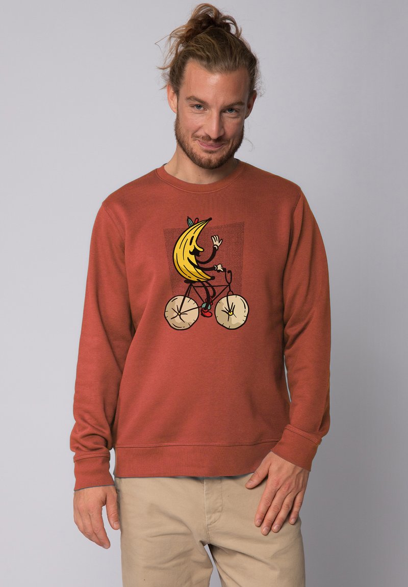 Rostfarbener Sweatshirt aus weichem Stoff, mit einem Cartoon-Bananencharakter, der in der Mitte Rad fährt. Lange Ärmel und Rundhals.