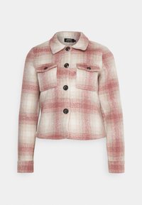 Ternet jakke i blødt stof med røde og beige toner, sorte knapper, to brystlommer og en krave. Kort croppet design.