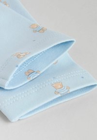 Hele sinine puuvillane kangas pehme tekstuuriga, millel on triibulise mustriga teddykaru, kaunistatud väikeste siniste täppidega õmbluste ääres.