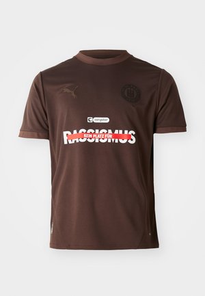 Braunes Sport-T-Shirt mit kurzen Ärmeln, mit einem roten und weißen Grafiktext, Puma-Logo auf der linken Brust und FC St. Pauli Emblem.