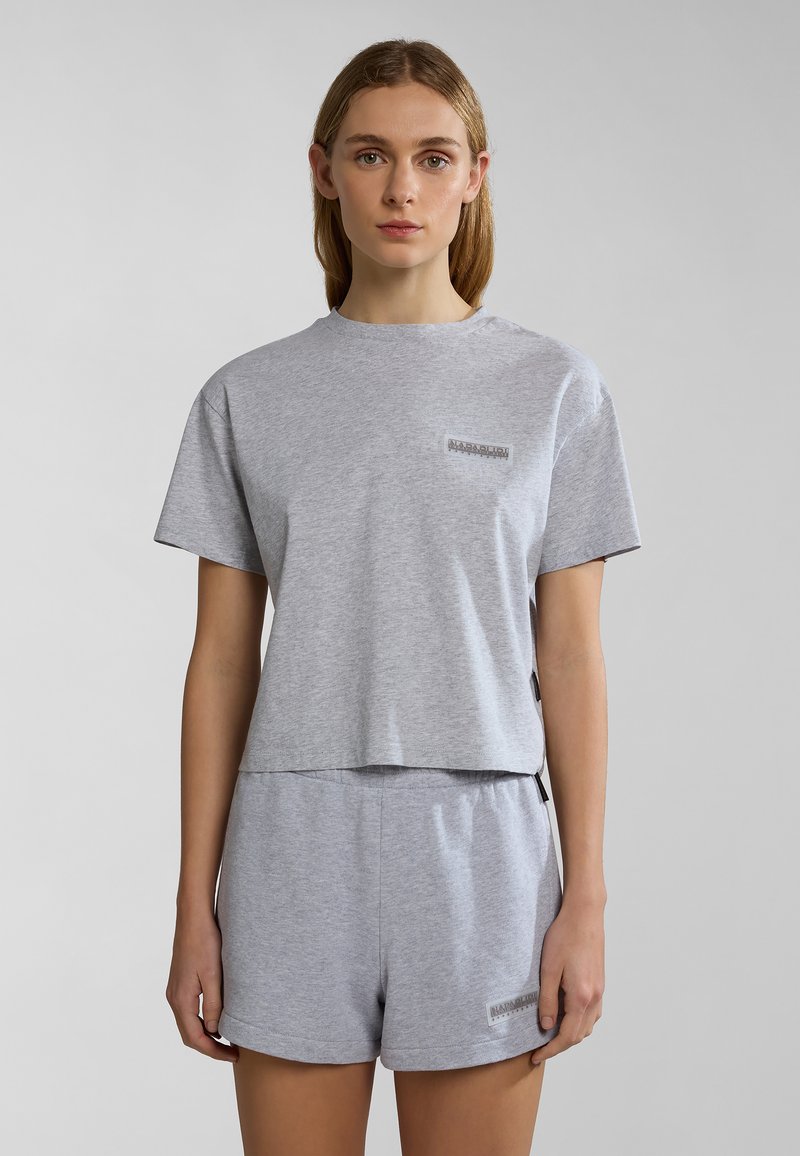 Grijze katoenen T-shirt met korte mouwen en een cropped ontwerp, voorzien van een klein logopatch, gecombineerd met bijpassende grijze shorts met een vergelijkbaar logo.