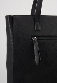 Czarna skórzana torba na ramię o gładkiej teksturze, z przednią kieszenią na zamek błyskawiczny i płaskimi uchwytami. Minimalistyczny design bez widocznych akcentów metalowych.