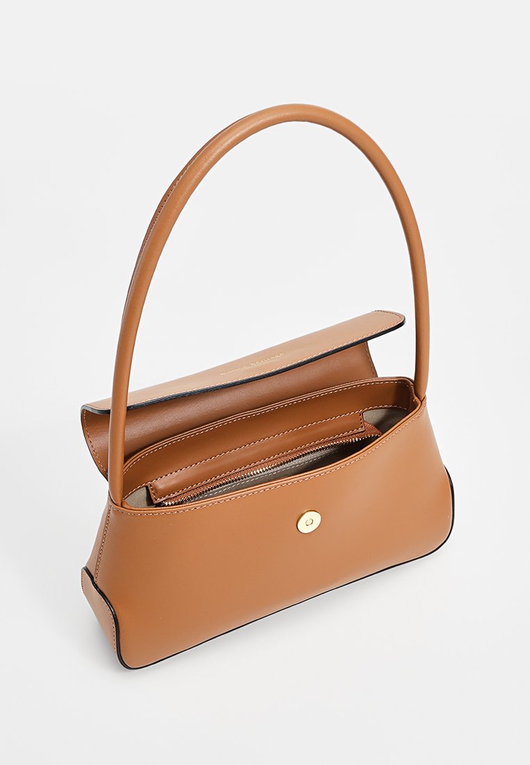 Tasche aus hellbraunem Leder mit rundem Griff, offenem Design, einem Reißverschluss-Innenfach und einem Druckknopfverschluss. Sie zeichnet sich durch klare Linien und eine glatte Textur aus.