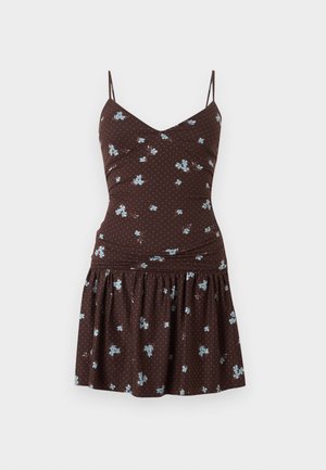 Robe marron sans manches avec fines bretelles, imprimé floral bleu clair, corsage ajusté et jupe froncée sur fond blanc.