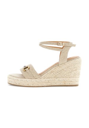 Sandale compensée beige avec plateforme en jute tressé, bride de cheville avec boucle, et bride avant avec un petit détail de boucle métallique.