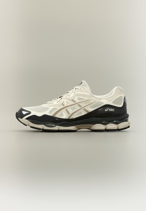 Beige and black Asics running shoe with mesh and synthetic upper, visible cushioning in sole, displayed on neutral background.