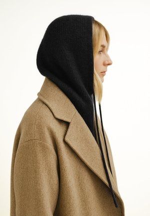 Brown wool coat with a black knit hood, featuring a textured surface, long drawstrings, and a structured collar, viewed from the side.
