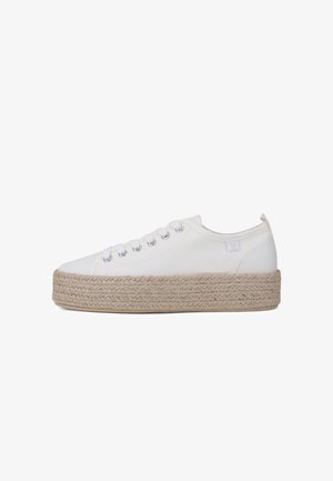Baskets en toile blanches présentant une semelle épaisse en jute tissé, avec six œillets métalliques et un patch logo discret sur le côté.