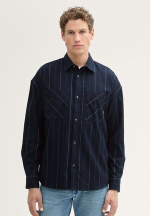 Himmelblau gestreiftes Hemd aus weichem Stoff, mit zwei vorderen Taschen mit diagonalen Nähten und einem Knopfverschluss. Lange Ärmel.