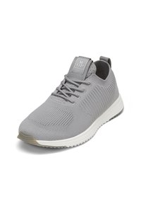 Baskets en tissu tricoté gris clair avec lacets à l'avant, semelle blanche et languette au talon, légèrement inclinées vers la droite.