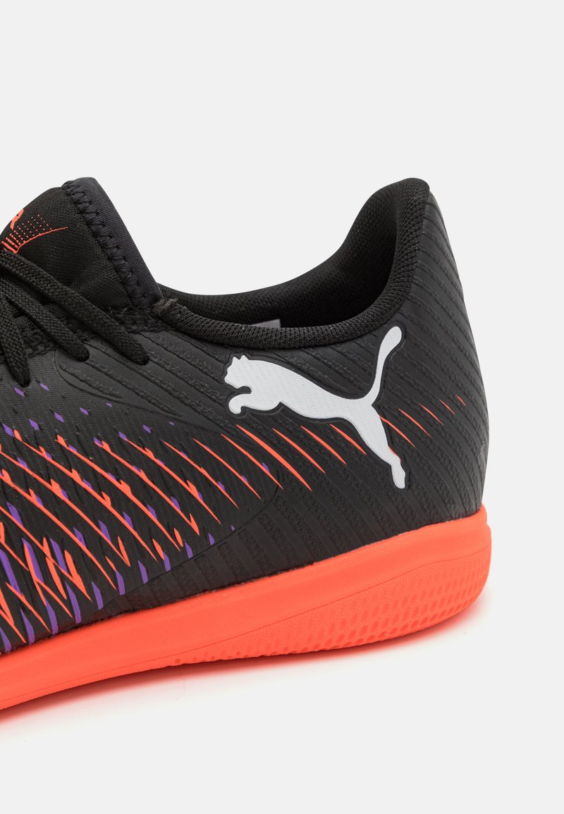 Czarne buty sportowe z teksturowaną cholewką, pomarańczowymi i fioletowymi akcentami oraz wyraźnym białym logo Pumy z boku. Gumowa podeszwa.