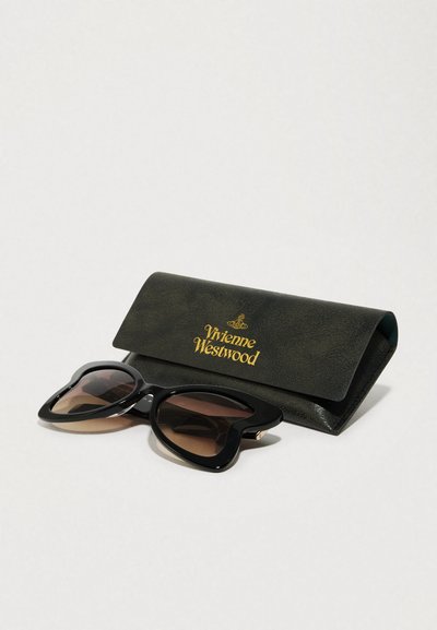 Czarne okulary w kształcie serca z gradientowymi brązowymi soczewkami obok ciemnozielonego etui z złotym logo "Vivienne Westwood".