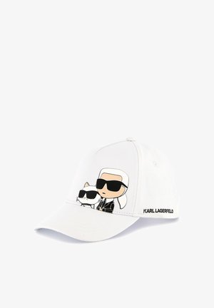 Casquette de baseball blanche ornée d'un design de cartoon représentant un personnage et un chat portant des lunettes de soleil. Comprend des accents noirs et le logo "KARL LAGERFELD".