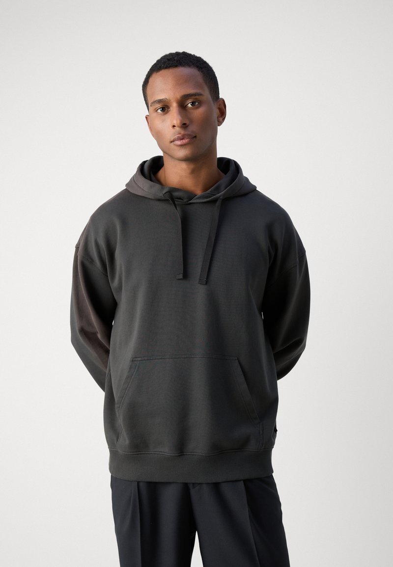 Donkergrijze hoodie met een contrasterende capuchon en zak. Gemaakt van zacht materiaal, met een relaxte pasvorm en geribde manchetten voor comfort.