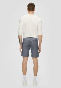 Herren graue Shorts aus strukturiertem Gewebe, mit Slim-Fit-Schnitt, zwei Gesäßtaschen und einem schlichten Design, kombiniert mit einem leichten Langarmhemd.