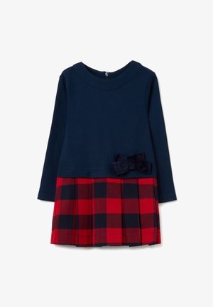 Vestido de manga larga azul marino con una falda de cuadros plisada en rojo y negro y un lazo a juego en la cintura.