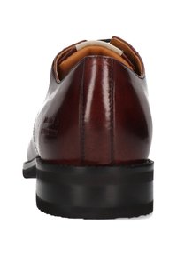 Scarpa da uomo in pelle lucida marrone vista da dietro, con suola nera e fodera interna imbottita beige.