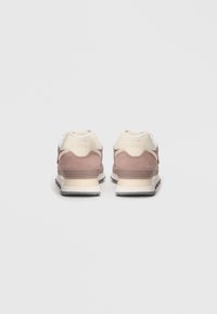 Rose-colored suede sneakers with a white leather heel tab, textured accents, and a rubber outsole, featuring "new balance" branding.
