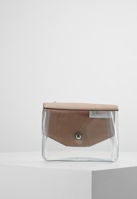 Sacoche transparente avec rabat en cuir synthétique marron clair. Dispose d'une fermeture à bouton-pression, d'une texture lisse et d'un design angulaire.