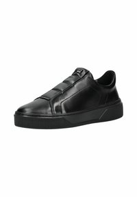 Baskets noires en cuir avec empiècements matelassés, bout rond et semelle en caoutchouc texturée avec des détails rayés.