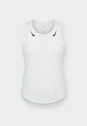 Fehér ujjatlan Nike Dri-FIT sportfelső perforált szellőzéssel és fekete Nike Swoosh logókkal a vállaknál.