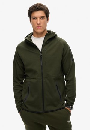 Dunkelgrüner Zip-Hoodie mit gefütterter Kapuze, Reißverschlusstaschen vorne und glatter Textur. Hat ein minimalistisches Design und eine taillierte Silhouette.