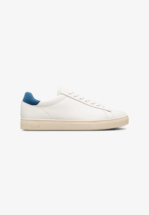 Sneakers bianche in pelle con una linguetta in suede blu sul tallone, lacci piatti e una suola in gomma beige testurizzata. Design minimalista con cuciture sottili.