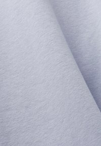 Tejido azul claro con una textura suave, que presenta un patrón de tela plana y variaciones sutiles en tonos. Material blando y flexible.