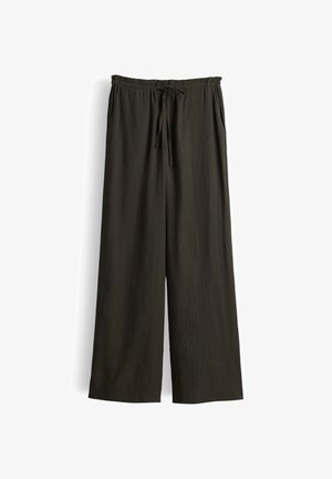 Pantalon ample vert olive foncé avec taille élastique et cordon ajustable, comprenant des poches latérales et une finition en tissu texturé.